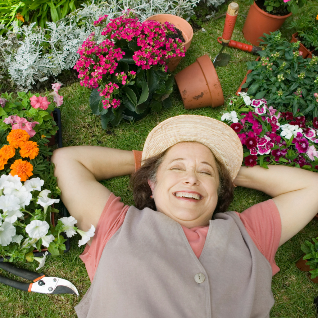 Woman laying on the floor between her flowers.